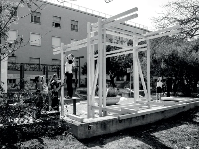Il padiglione in legno quasi completato occupa una piattaforma nel giardino.